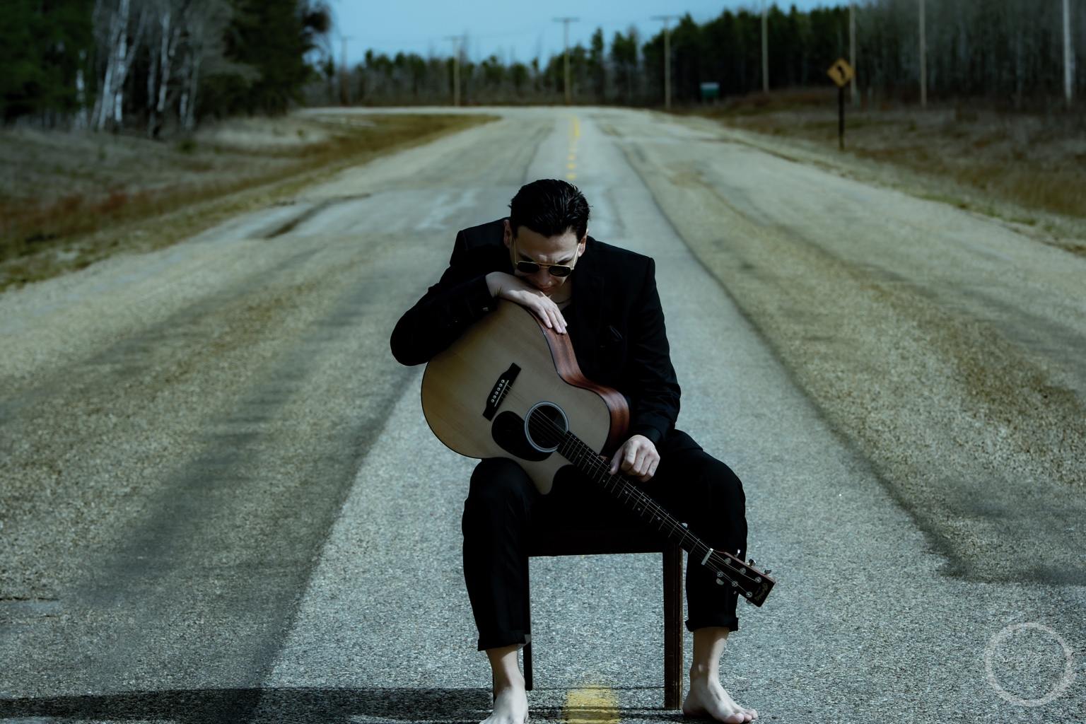 Dakota Favel resting his head on an acoustic guitar while seated