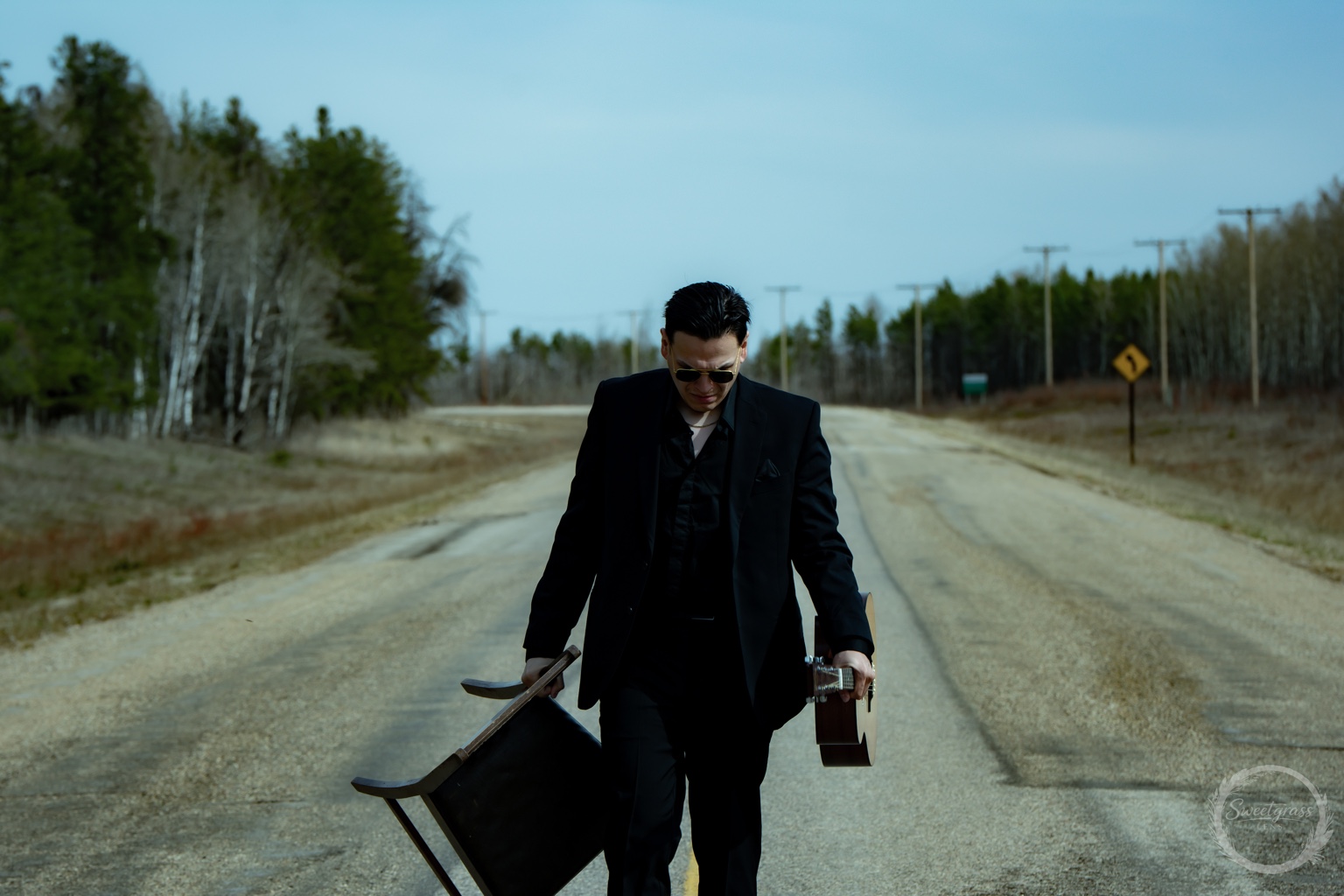 Dakota Favel walking with a chair and acoustic guitar